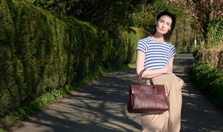 model wearing Mulberry Bayswater bag in burgundy leather
